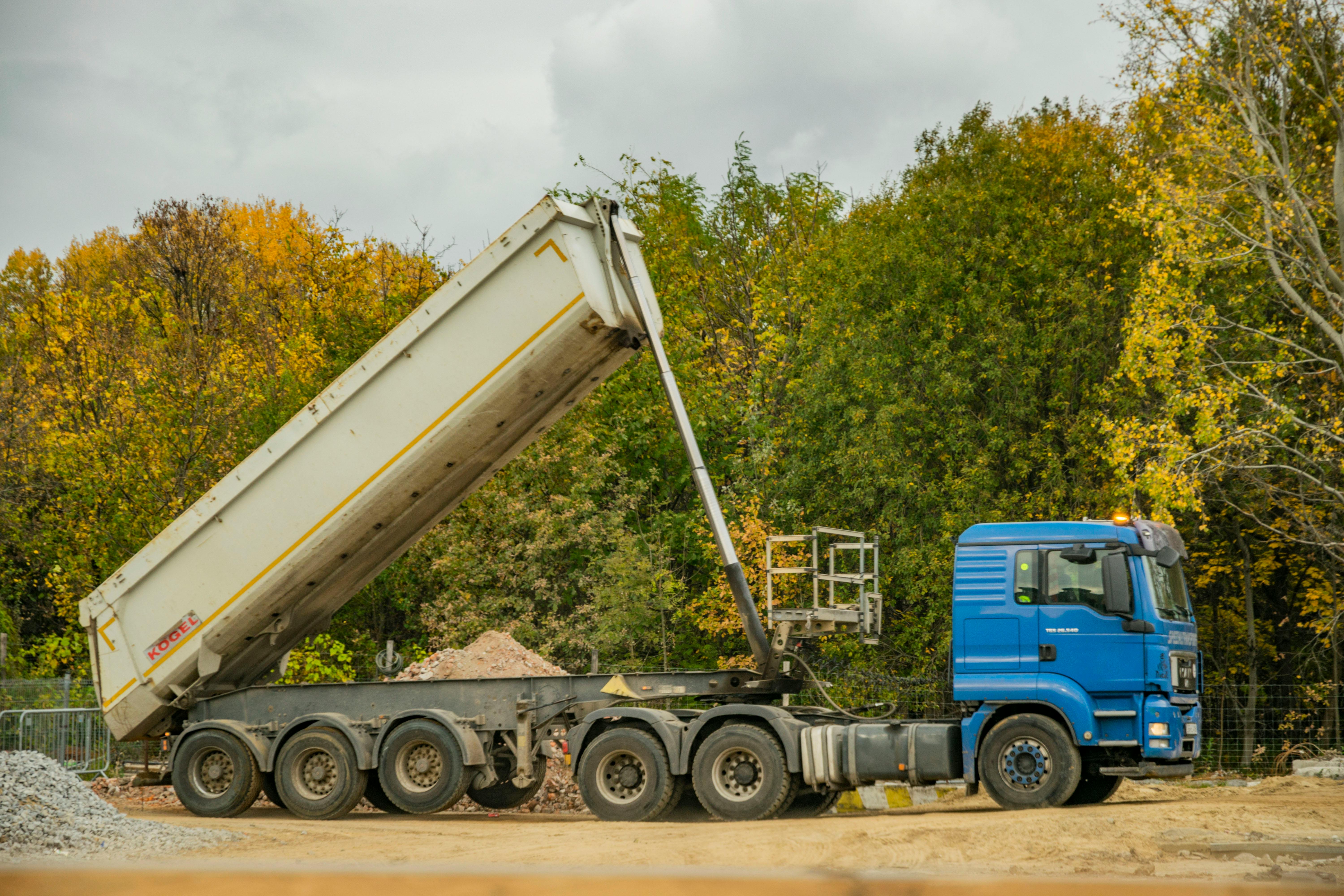 Construction dump truck unloading material on an active Macomb County job site